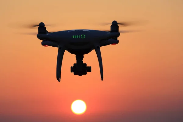 Drone telecomandato che vola nell'aria e nel cielo del tramonto — Foto Stock