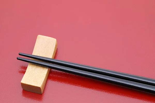 Paar Schwarze Essstäbchen Auf Rotem Tablett Hintergrund — Stockfoto