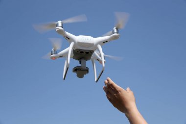 Drone uçakları hava fotoğrafçılığı fotoğraf makinesi operatörü kavramı mavi gökyüzü arka planda yakalamak el