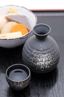 Japon geleneksel sake fincanı ve tepside oden ile birlikte şişe.  