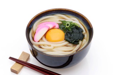 Japon Tukimi udon erişteleri beyaz arka planda çubuklarla dolu bir kasede.