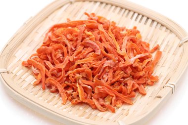 Beyaz arka planda izole edilmiş bambu sepetinde kurutulmuş havuç. 