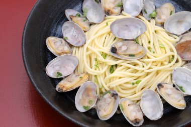 Vongole spagettisini ahşap masada bir tabakta kapat.