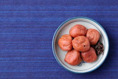 Japon yemeği, Umeboshi turşusu. Masanın üstünde, en üstte.
