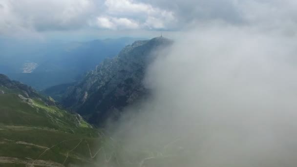Vista aérea en vuelo de Bucegi montañas, Rumania, en la primera capa de nubes — Vídeos de Stock