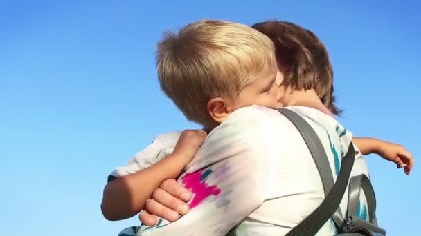 Liten pojke i mödrar vapen mot blå himmel, Slowmotion — Stockvideo