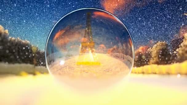 Eiffeltoren gezien door een glazen bol, winter vakantie achtergrond — Stockvideo