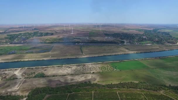 Luchtfoto vlucht boven de wijngaarden en de rivier van Donau met windmolens op de achtergrond — Stockvideo