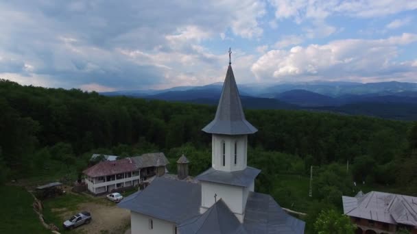 Chrześcijański Kościół na szczycie zielonego wzgórza, widok z lotu ptaka, aparat fotograficzny, malejąco — Wideo stockowe