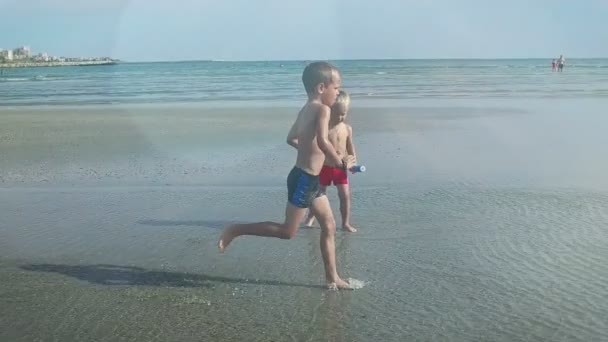 Little boy running on a beach, flares, slow motion — Stock Video