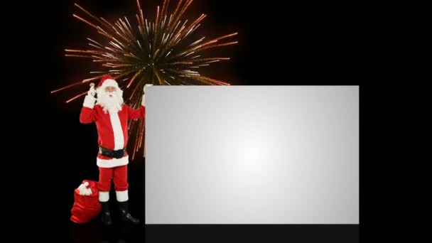 Santa Claus protřepání bell představují bílý list, proti dovolené ohňostroj — Stock video