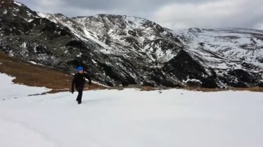 Kışın dağ tepe üzerinde yürüyüş genç adam