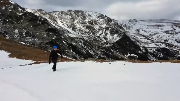 若い男の冬の山の頂上にハイキング — ストック動画