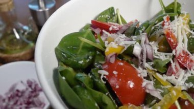 Bir ıspanak salatası dolmalık biber ve domates, ağır çekim 1000 FPS düşüyor Parmesan peyniri