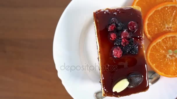 Turuncu dekorasyon, döndürme, üst görünüm, 4 k ile beyaz bir plaka üzerinde meyve pasta dilimi — Stok video