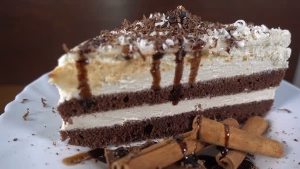 Шоколадне гоління падає на шматочок торта, обертаючись, 4k — стокове відео