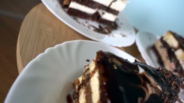 Різні скибочки тортів на білих тарілках, що обертаються, крупним планом, 4K — стокове відео