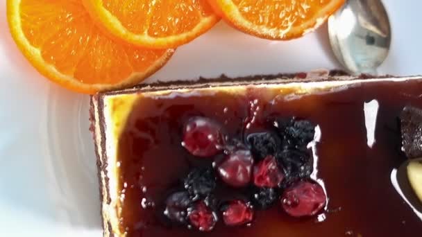 Кусочек торта фрукты на белом фоне с апельсинами, пространство для текста, вращающиеся, верхней точки зрения, крупным планом — стоковое видео