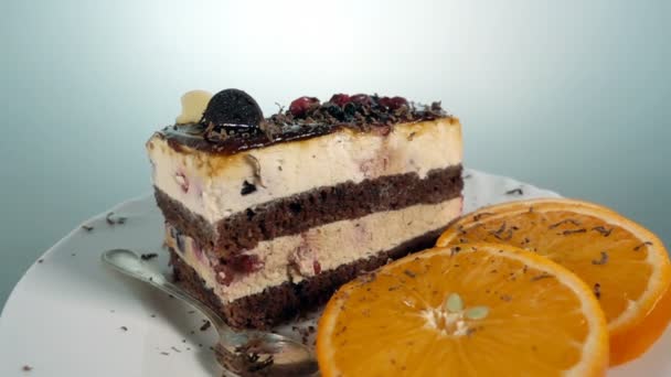 Шоколадна гоління падає на шматочок фруктового торта, повільний рух при 500fps, обертається — стокове відео