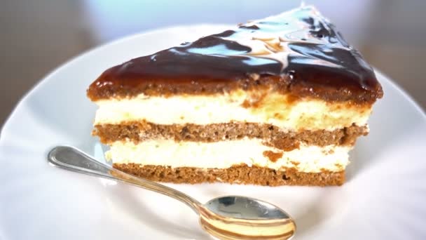 Fatia de bolo de chocolate num prato branco, rotacionando, vista superior, 4k — Vídeo de Stock
