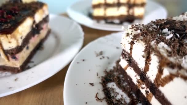 Різні скибочки тортів на білих тарілках обертаються, 4K — стокове відео