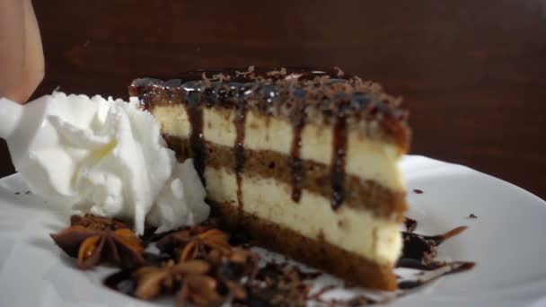 Кусочек шоколадного торта с анисом, взбитые сливки на 500 fps — стоковое видео
