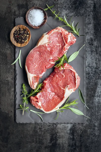 향신료와 허브 그리고 슬레이트 평면도에 원시 쇠고기 스테이크 — 스톡 사진