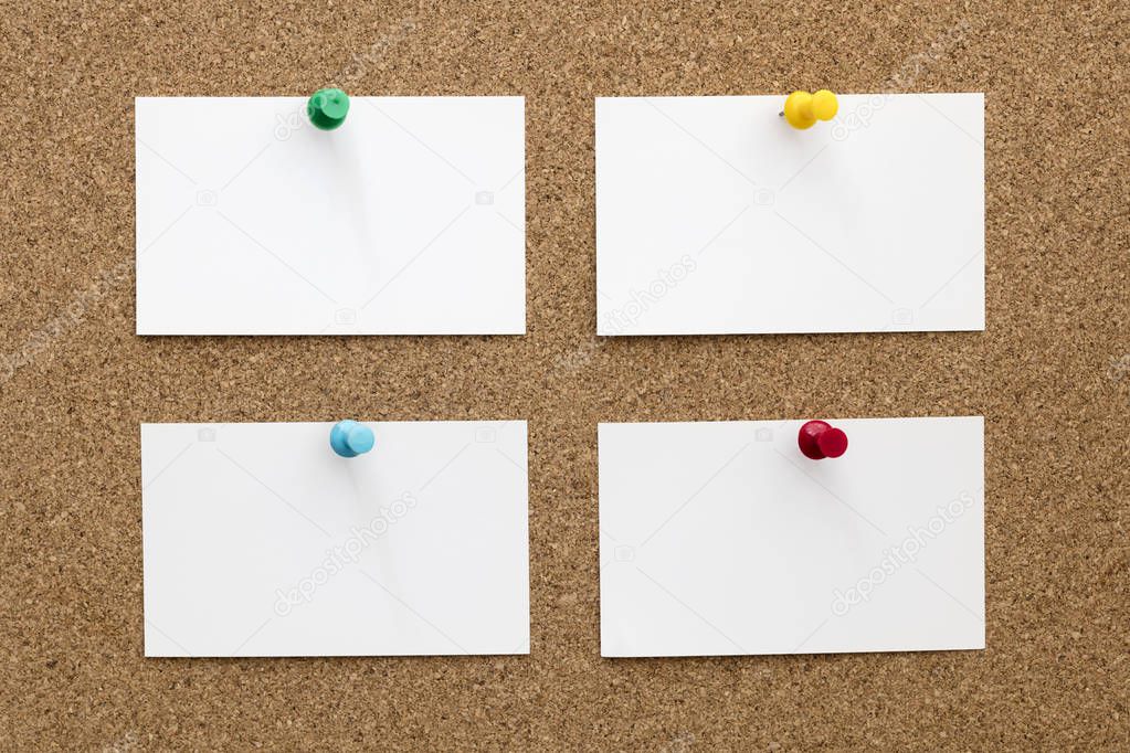 Four Blank Business Cards Pinned to Cork Board