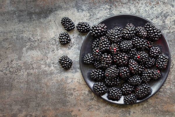 Blackberries on Black Plate over Slate Top View