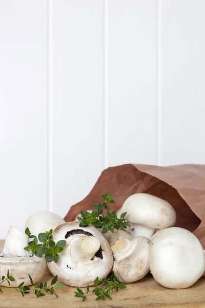 Cogumelos de botão e tomilho sobre fundo de madeira — Fotografia de Stock