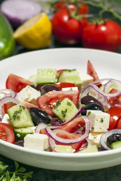 Griekse salade met ingrediënten achter — Stockfoto