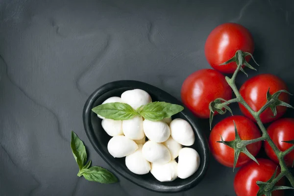 Mat bakgrund skiffer med Baby Mozzarella bollar vinstockar tomater en — Stockfoto