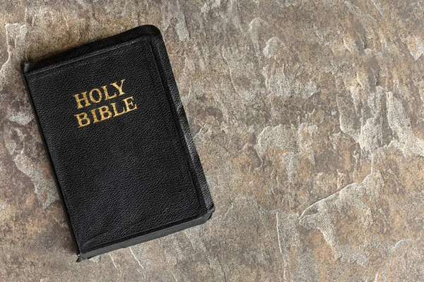 Velha Bíblia Fechado vista superior sobre fundo de pedra — Fotografia de Stock