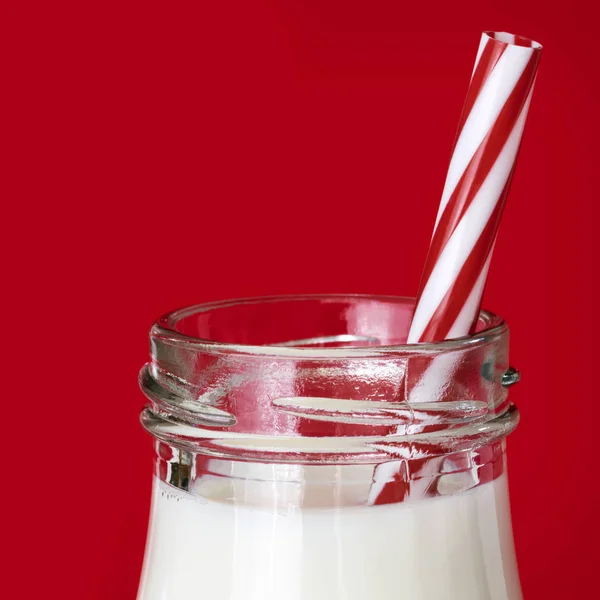 Bottiglia di latte con paglia su fondo rosso — Foto Stock