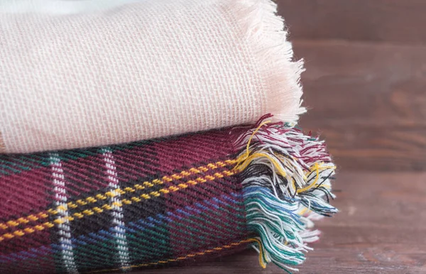 Ζεστό σωρό κουβέρτες βρίσκονται σε ένα ξύλινο φόντο — Φωτογραφία Αρχείου