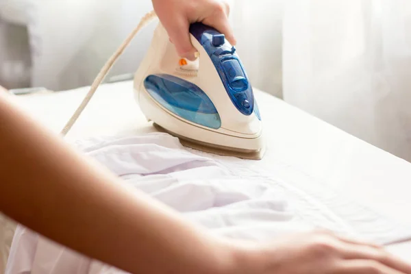 Vrouw strijken ijzer wit shirt — Stockfoto