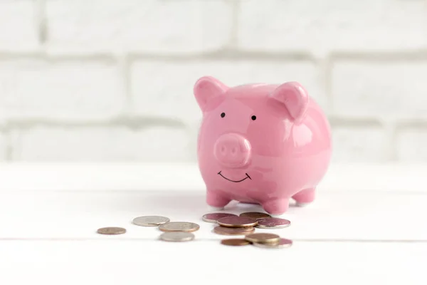 Arka planda pembe domuzcuk kumbarası ve bozuk paralar. Nakit tasarrufu