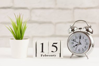 15 Şubat, ahşap takvimde, arka planda. Saat ve takvim, yılın bir günü konsepti.