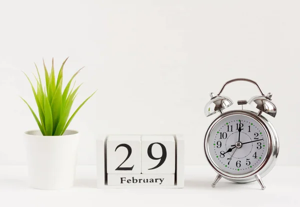 29 februari op een houten kalender naast de wekker. Kalender datum, vakantie of verjaardag.De laatste dag van de wintermaand. 29 februari gebeurt om de vier jaar. — Stockfoto
