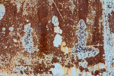 Kahverengi ve sarı pas, üzerinde mavi boya kalıntıları olan metal bir levha. Paslı soyut doku. Paslı metal arkaplan.