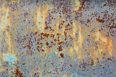 Kahverengi ve sarı pas, üzerinde mavi boya kalıntıları olan metal bir levha. Paslı soyut doku. Boyanın içinde pas var..