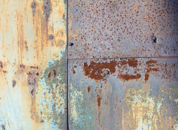 Bruin en geel roest op het metalen blad met de resten van blauwe verf. Roestige abstracte textuur. Roest door de verf. — Stockfoto