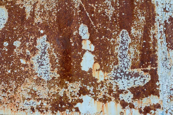 Brown and yellow rust on the metal sheet with the remnants of blue paint. Rusty abstract texture. Rusted metal background. Royalty Free Stock Images