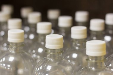 Su ve içecekleri doldurmak için kapaklı yeni plastik şişeler