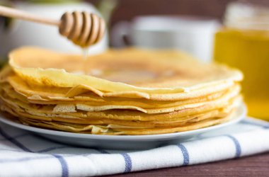 Tabağında bal olan taze pişmiş krep. Geleneksel ev yapımı kekler. Maslenitsa.