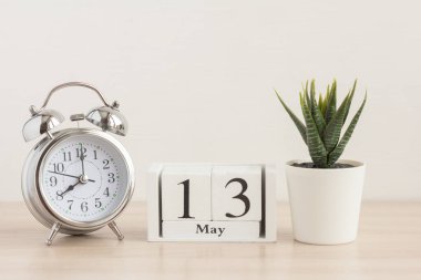 13 Mayıs, ahşap takvimde. Ayın 13 günü, takvim ve alarmlı saat. Avluda bahar, metin için boş boşluk