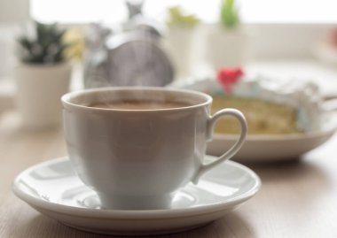 Masada süt olan bir fincan sıcak kahve.