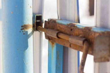 Eski paslı sürgü ya da yıpranmış yeşil bir kapının sürgüsü.