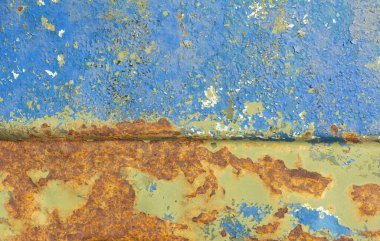 Parlak turuncu benekleri olan eski bir metal kutu. Eski paslı metal üzerindeki boyayı soyuyordu..