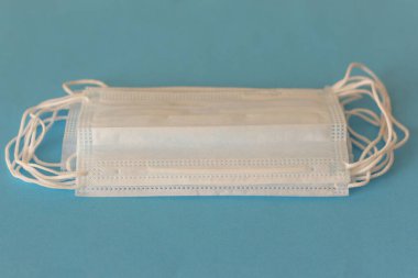 Enfeksiyonlara karşı korunmak için antiviral tıbbi maske. Mavi arka planda bir sürü tıbbi yüz maskesi. COVID-19 virüsünün yayılmasına karşı birincil koruma.